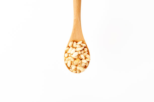 istock puffed rice on Wooden spoon white background 1320724604