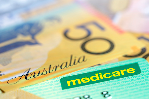 Tarjeta australiana de Medicare sobre dinero.  Enfoque superficial, con espacio de copia. photo