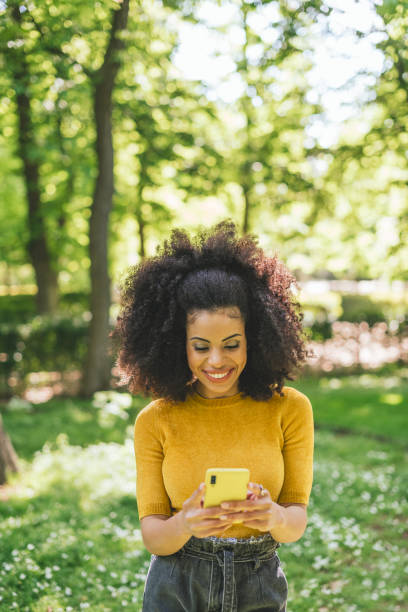 istock Pretty and happy afro woman typing on mobile. 1320731054