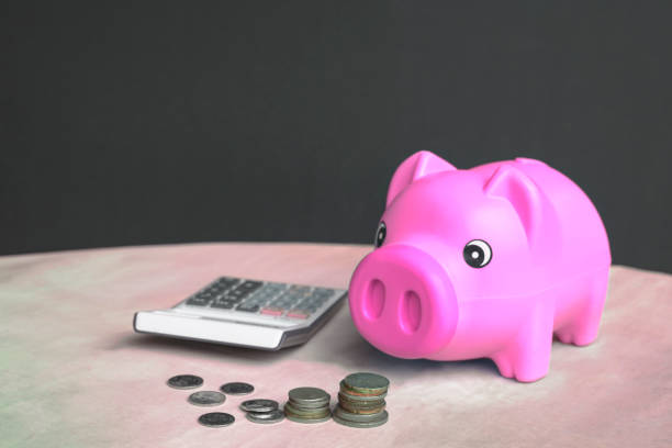 istock Piggy bank, calculator and money on table 1320732472