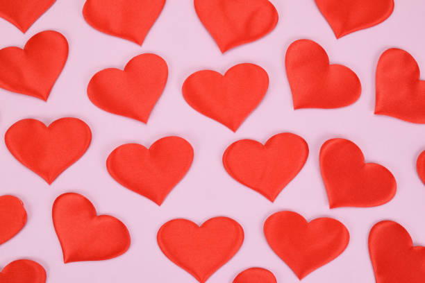 istock Festive pattern of red decorative hearts on a pink background 1320738678