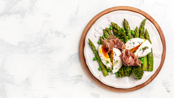 istock Green Asparagus with Poached Egg and jamon serrano, ham, prosciutto, ketogenic diet lunch concept. menu, top view 1320738829