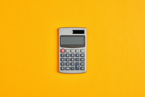 Calculadora sobre fondo amarillo. Cálculo en negocios, finanzas o educación photo