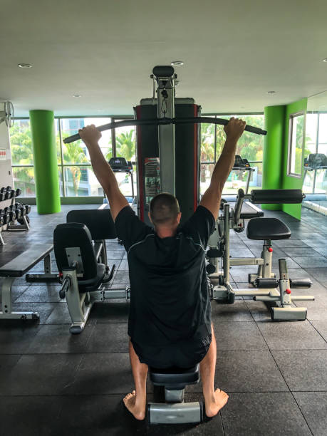 istock Man is engaged in sports, makes exercises on simulators in the gym 1320740514