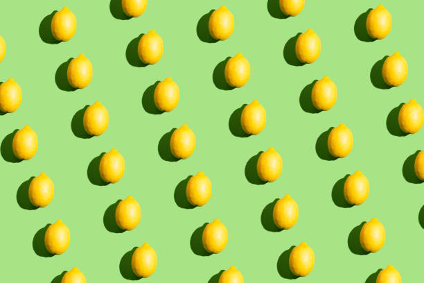 istock Colorful pop art style repetitive pattern made of lemons with hard shadow on green background 1320740580