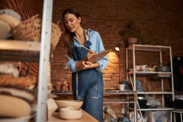 istock Happy smiling Caucasian female sculptor working in pottery workshop 1320746172
