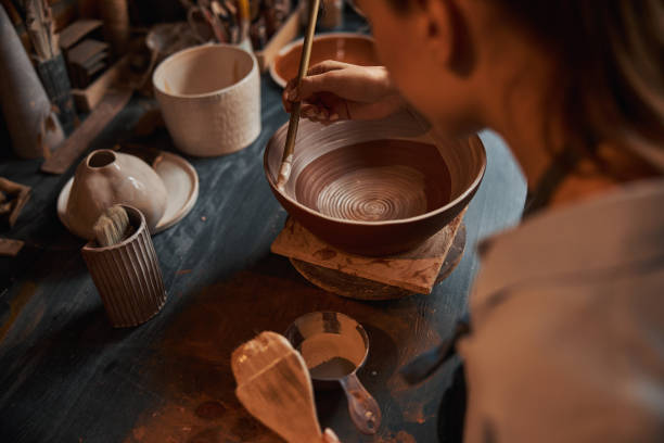istock Beautiful elegant female artisan during painting process of ceramic tableware in pottery workshop 1320746710