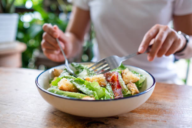 istock a woman eating a Caesar salad 1320761826