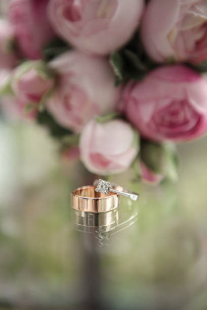 istock White gold wedding ring on flower background 1320763060