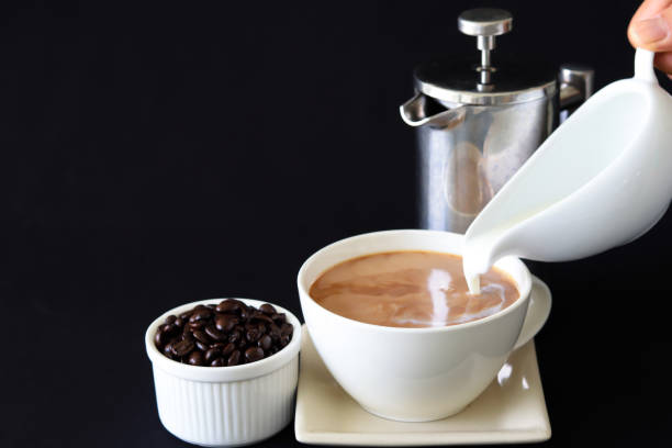istock Pouring milk into coffee cup 1320764060