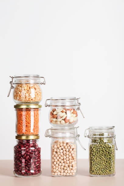 istock Vegan protein source. Beans, peas, chickpeas, lentils, mung, peanut in glass jars on white and beige background. Healthy vegetarian food. copy space 1320764719