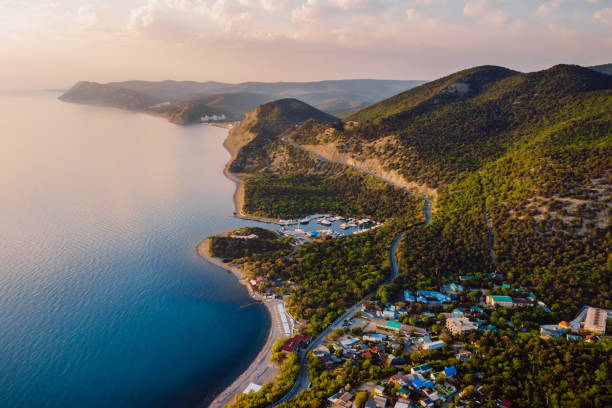 istock Aerial view of coastline with blue sea, mountains with trees, cliffs with sunset light. 1320765134