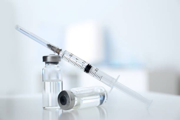 istock Syringe with vials of medicine on white table 1320766830