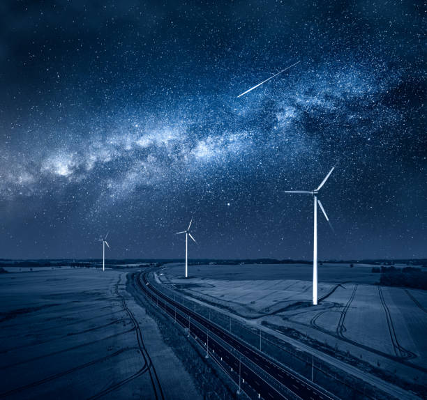 istock Milky way and wind turbines by highway. Alternative energy, Poland. 1320768942