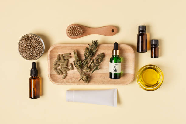 Cannabis oil extract, hemp seeds, dried leaf and hemp moisturizer on yellow background top view. Medical marijuana cbd oil. Cannabis oil extract, hemp seeds, dried leaf and hemp moisturizer on yellow background top view. Medical marijuana cbd oil. Alternative beauty treatment, herbal natural cannabis cosmetics. cannabinoid stock pictures, royalty-free photos & images