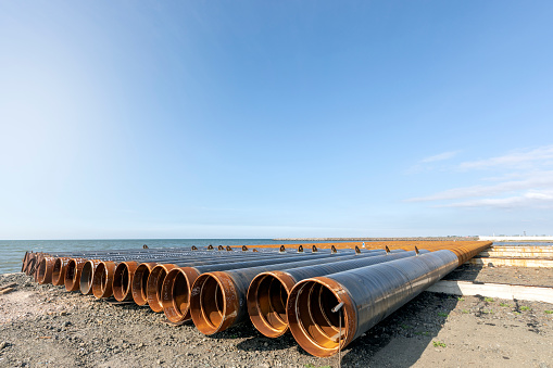 View of the steel pipe piles to build pier in the sea. Offshore piles have been commonly used as a foundation element of offshore structures, especially large structures such as tension leg platforms.