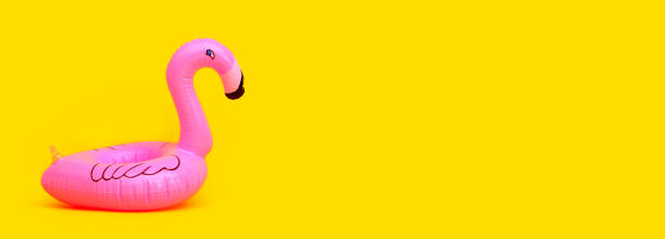 istock flamingo inflatable swimming pool ring on yellow background. 1320772588