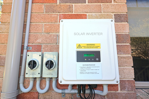 Solar inverter and isolating switches on the side of a house