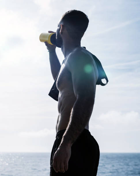 jovem em forma bebendo um pouco de água de uma garrafa e descansando após o treinamento. treino matinal ao ar livre - crossfit exercising sports training outdoors - fotografias e filmes do acervo