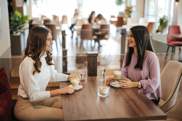 istock Two cheerful female friends having fun during coffee time in a cafe 1320777042