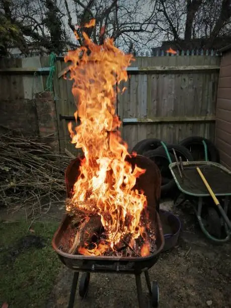 A wood fire burning in a metal barbecue.