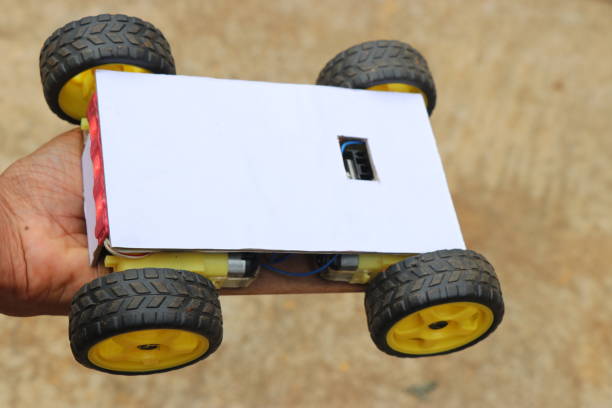 istock Robotic car having 4 wheels all powered by powerful plastic geared motors held in hand. Smartphone controlled robotic car project working model 1320777964
