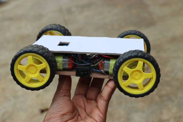 istock Wireless remote controlled robotic car made for science project. Robot car working model in hand 1320777967