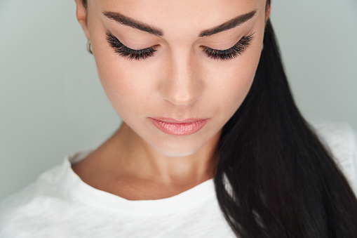 girl with extended silk eyelashes and eyes closed in a beauty studio