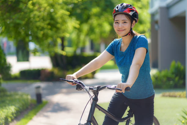 매일 건강과 웰빙을 위해 자전거를 타는 동안 행복해 보이는 아시아 여성은 신체적, 정신적 건강을 위해 이웃을 돌아다녔습니다. - mental health women asian ethnicity bicycle 뉴스 사진 이미지
