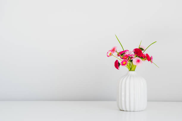 istock Pink spring flowers in vase on white background. Minimal style. 1320786856