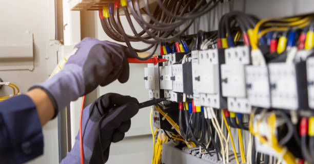 istock Electrician engineer tests electrical installations and wires on relay protection system. Adjustment of scheme of automation and control of electrical equipment. 1320788031