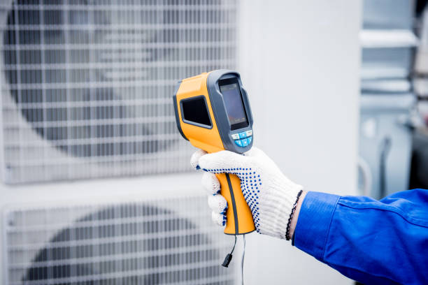 istock Technician uses a thermal imaging infrared thermometer to check the condensing unit heat exchanger. 1320792063