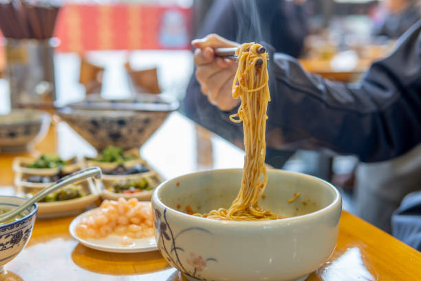 istock Asian man eating noodles with crab roe and shrimp 1320793395