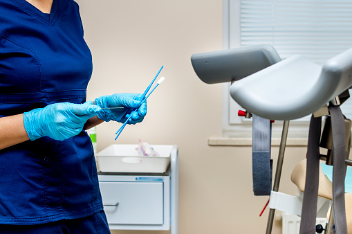 ginecólogo sostiene instrumentos para tomar pruebas de una mujer. Consultorio del ginecólogo photo