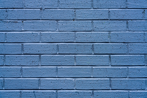 A simple background close-up of a recently painted blue brick wall surface.