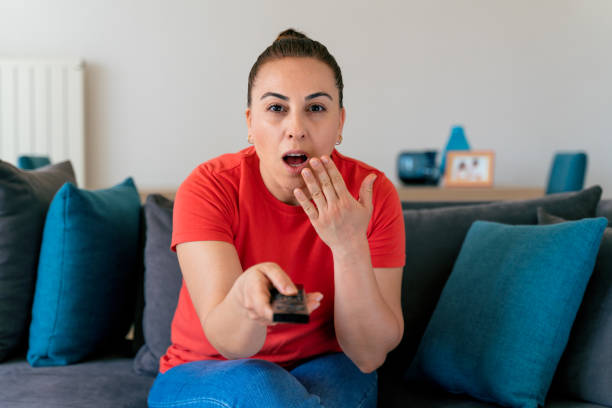 istock Shocked woman watching tv 1320796758