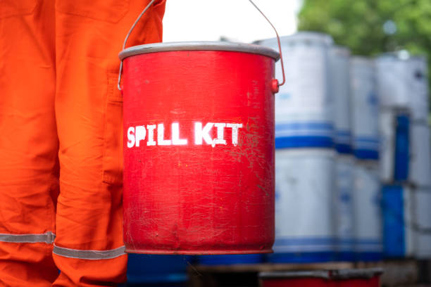 una squadra di soccorso tiene in mano la scatola rossa di "spill kit" - scena di emergenza industriale. - oil slick foto e immagini stock
