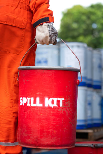 une équipe de sauvetage tient la boîte rouge de « spill kit » - scène d’urgence industrielle. - chemical accident photos et images de collection