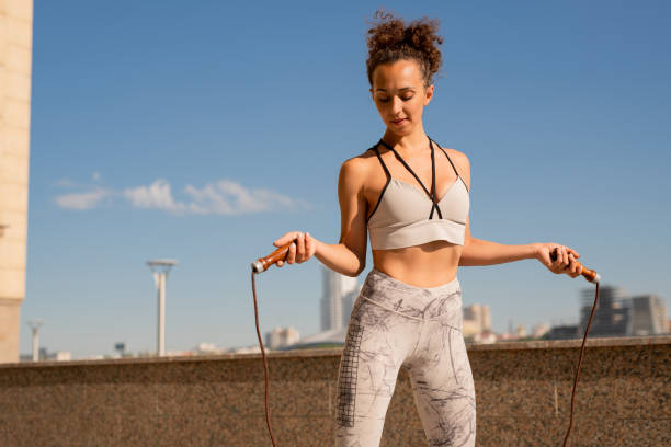 istock Fit young active female with skipping-rope exercising outdoors in the morning 1320798212