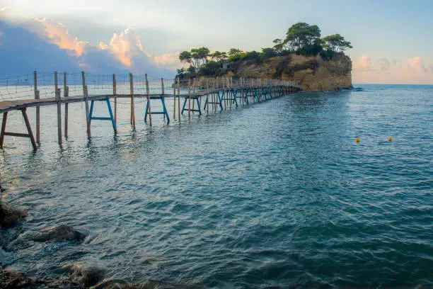 Photo of Scenic view of the island in the Ionian Sea with a wooden bridge leading to it