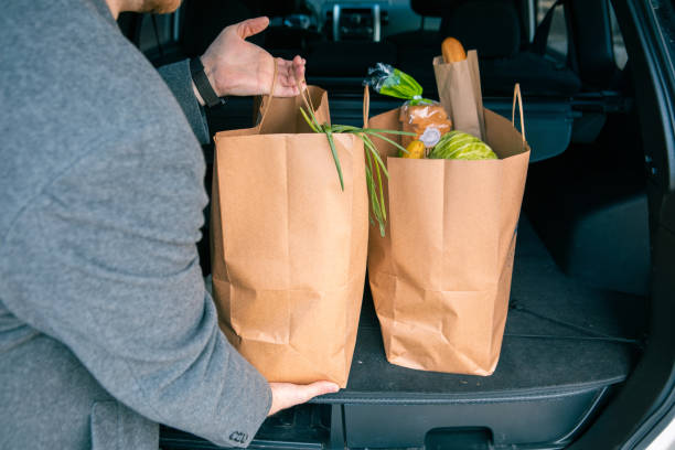 istock man putting bags with product in car trunk 1320798906