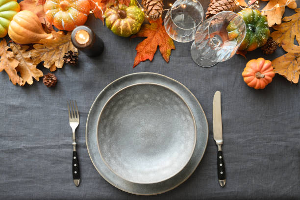 istock Autumn and Thanksgiving day table setting with empty plate as mockup decorated fallen leaves, pumpkins. 1320801373