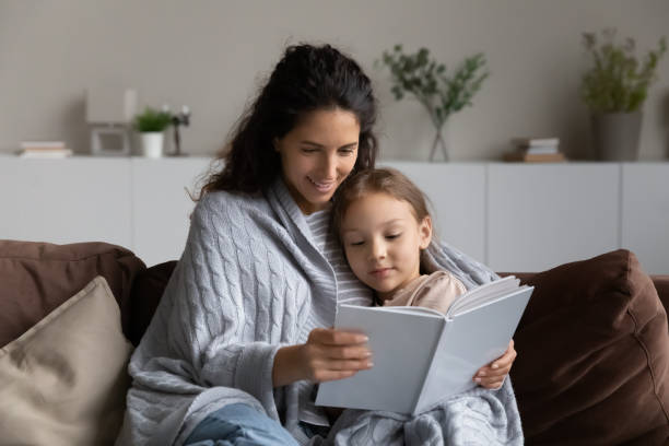 istock Loving Hispanic mom and daughter relax reading book 1320801523