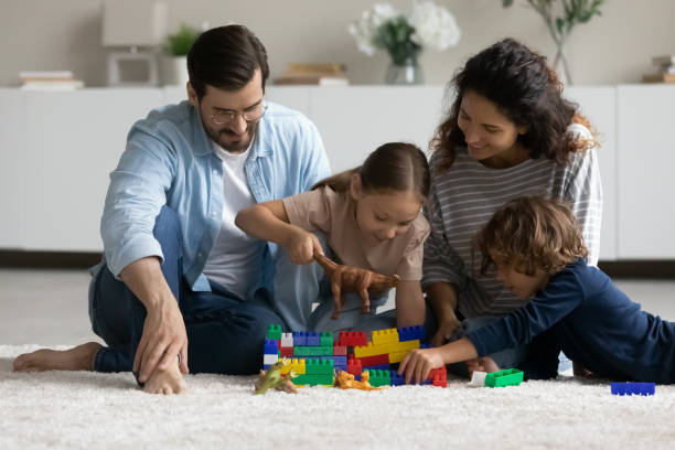 istock Happy multiracial parents play with small children 1320801546