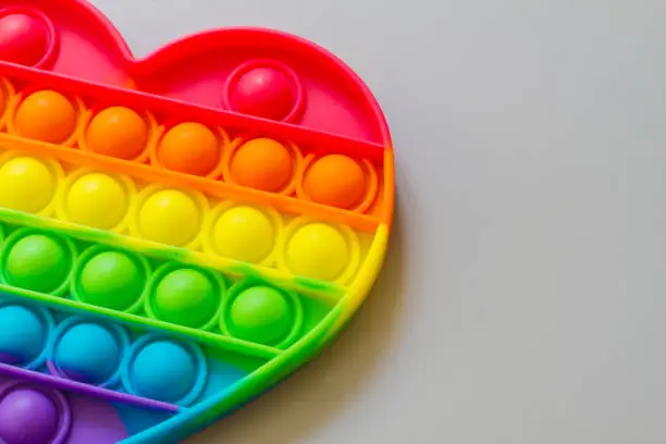 Photo of Pop it, A relaxing rainbow-colored toy for Tapping heart-shaped bubbles with your fingers