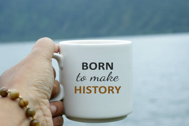 istock Text on coffee cup in hand - Born to make history. 1320801592