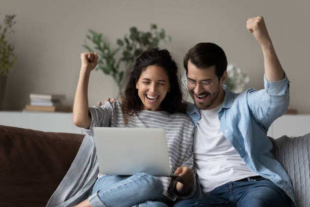 istock Excited multiracial couple celebrate online win on laptop 1320801607