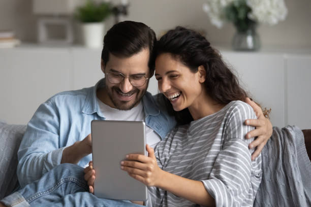istock Smiling multiethnic couple use modern tablet at home 1320801627