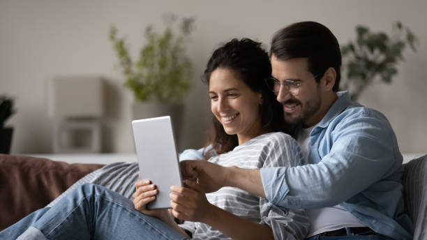 istock Smiling multiracial couple use tablet talk on webcam call 1320801637