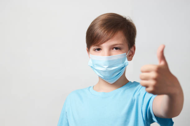 istock School boy with face mask on white background 1320802807